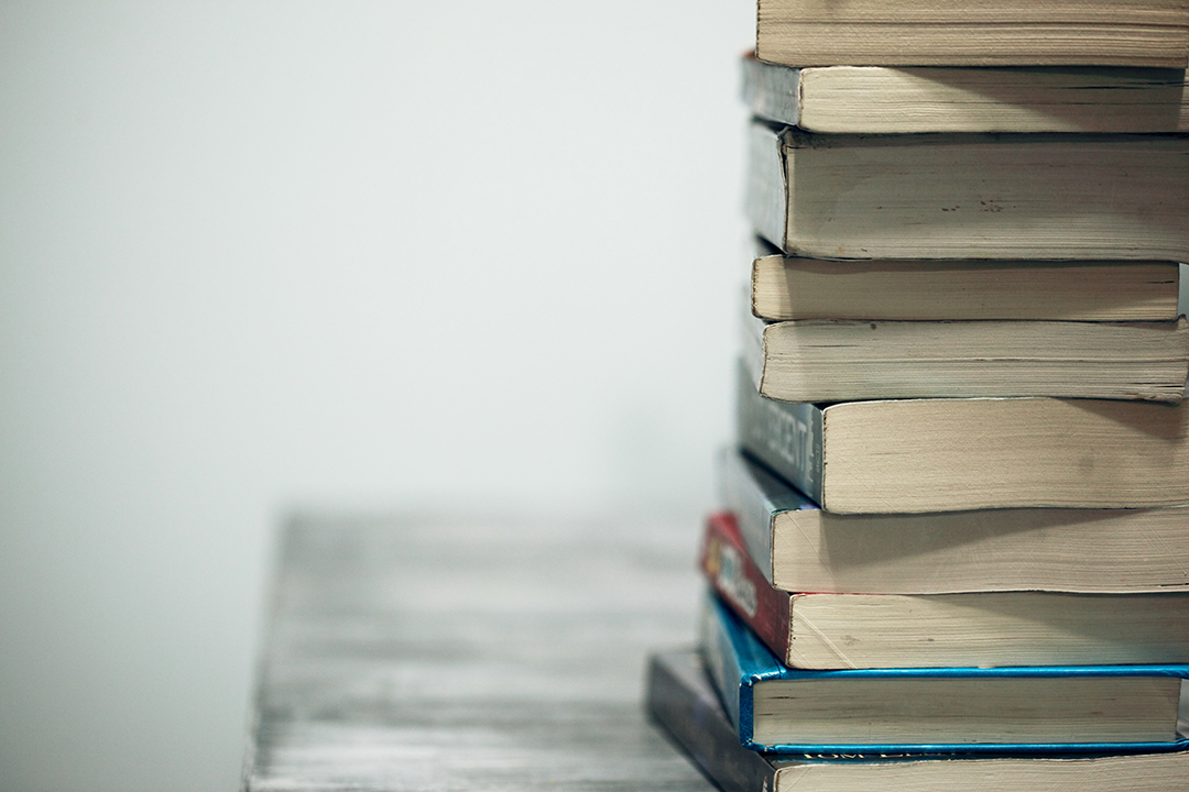 stack of books on a wooden table