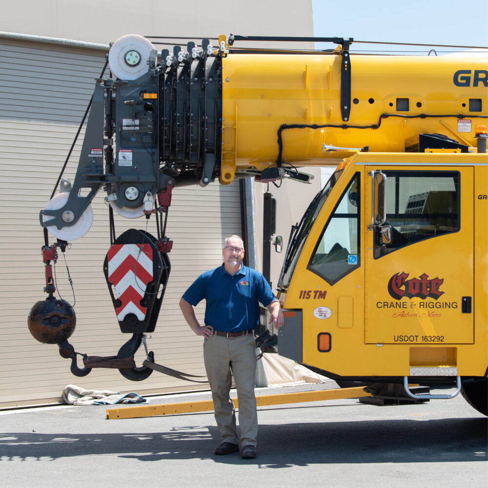 Daniel Cote standing in front of a crane