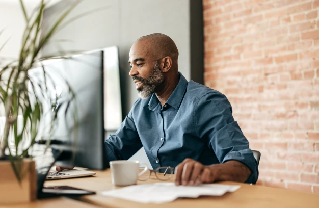 Man smiling while using a desktop computer