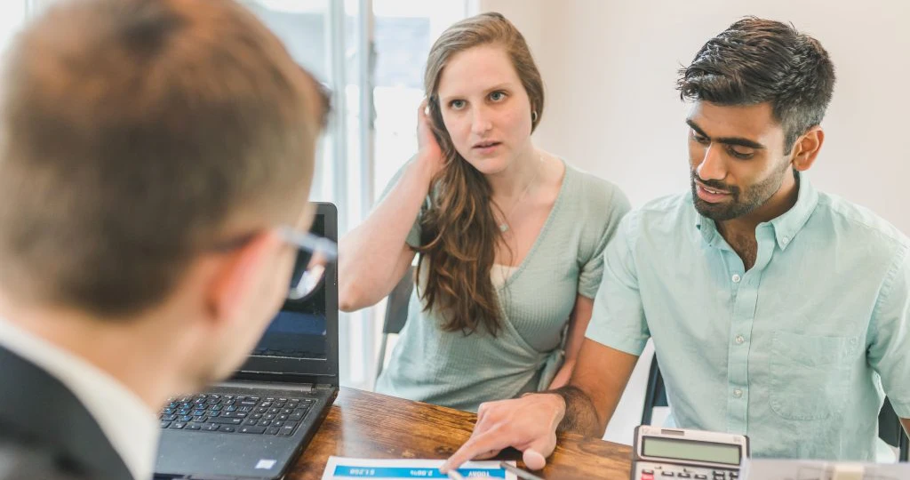 a couple discussing strategy with a financial coach